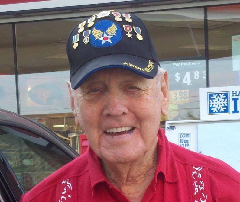Man in red shirt smiles into camera wearing Army Air Coprs hat